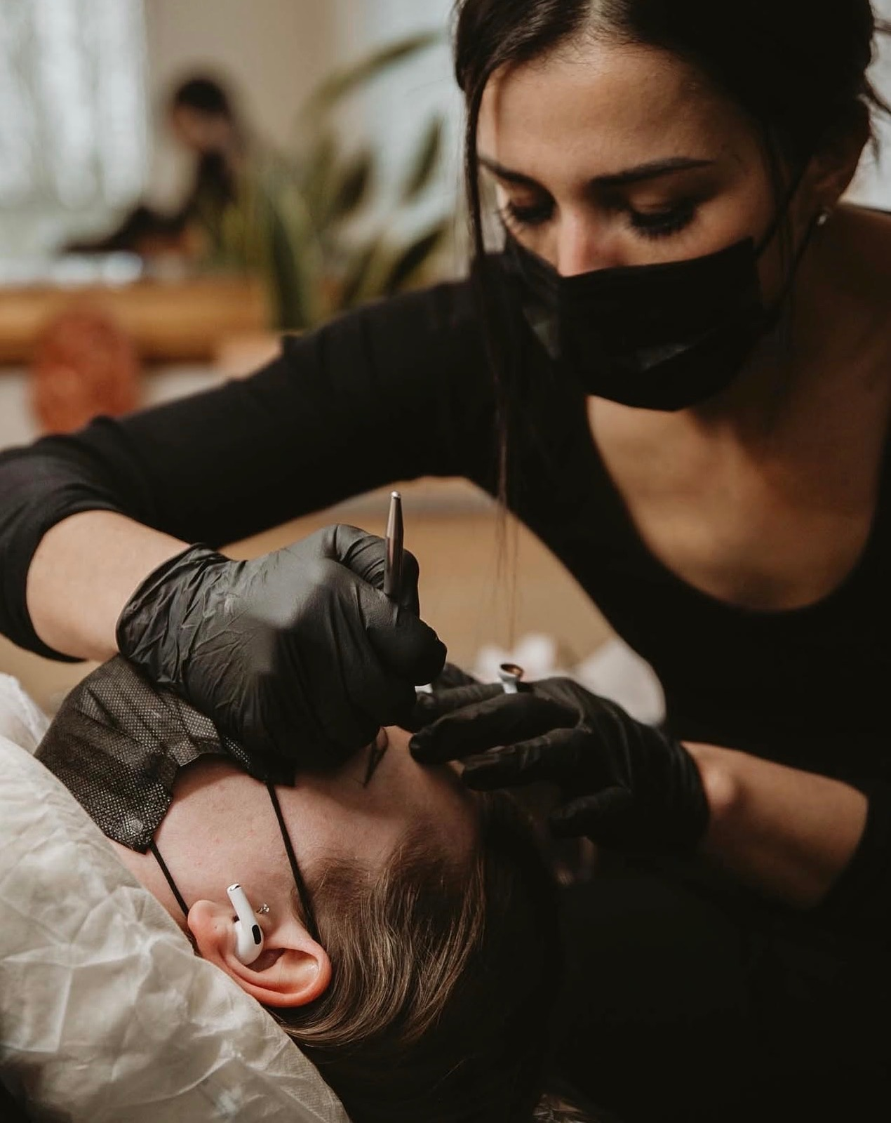 Elle P. performing precision permanent makeup work on a client